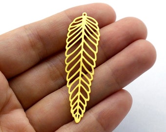 May include: Gold metal leaf charm with a delicate, intricate design. The charm has a hole at the top for attaching to jewelry or other crafts.