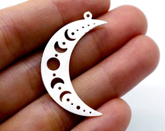 May include: Silver crescent moon charm with a cutout design of various moon phases. The charm has a small loop at the top for attaching to jewelry.