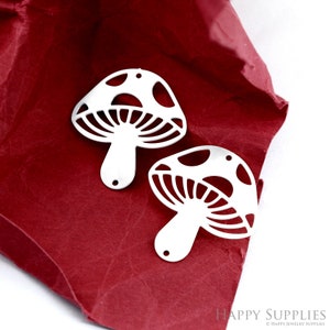 May include: Two silver mushroom-shaped charms with a cutout design. The charms have a hole at the top for attaching to jewelry.