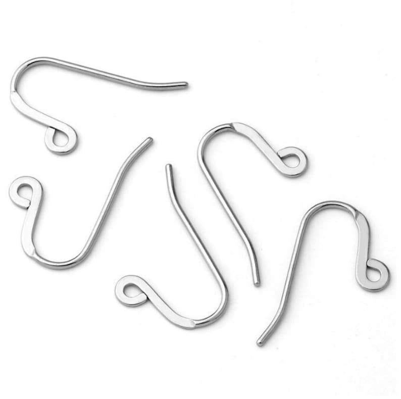 May include: A collection of silver-colored earring hooks, displayed against a white background. The hooks have a curved design with a looped end for attaching earrings. The hooks are made of a shiny, metallic material.