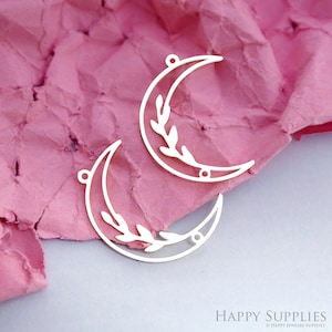 May include: Two silver metal crescent moon charms with a leafy branch design. The charms have two holes for attaching to jewelry.