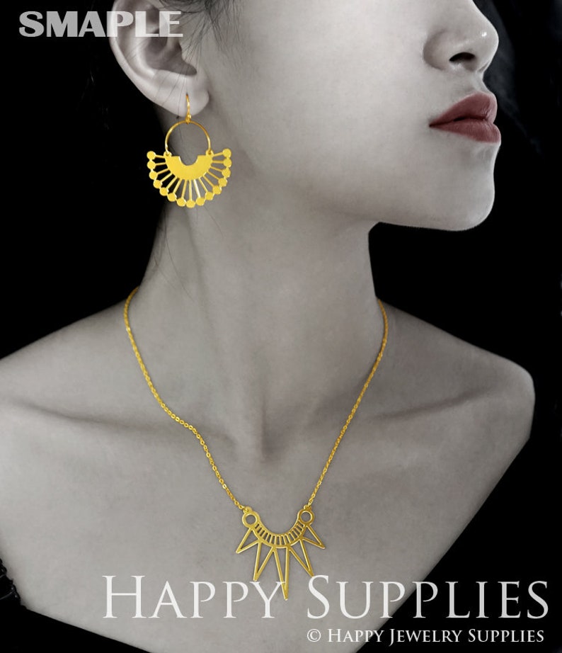 Pu&ograve; includere: Una collana d'oro con un ciondolo geometrico e un paio di orecchini abbinati in oro con un design a forma di ventaglio. I gioielli sono esposti su un manichino con uno sfondo nero. Il testo "HAPPY SUPPLIES" &egrave; visualizzato nella parte inferiore dell'immagine.