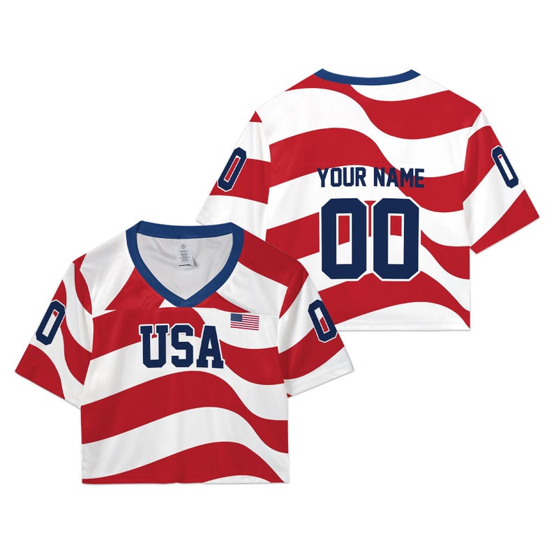 May include: A cropped V-neck jersey featuring a wavy red and white striped pattern. The front displays the text USA in navy blue with a small American flag. The back shows the text YOUR NAME and the number 00 in navy blue, with 0 on each sleeve.