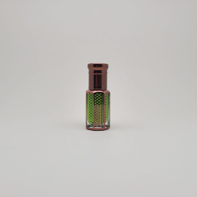 Close-up view of Mosswood Oud natural fragrance oil bottle with a white backdrop, showing the rich amber hue of the oud oil inside