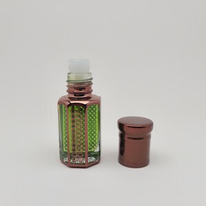 Elegant presentation of Mosswood Oud natural oud fragrance oil in a clear bottle, placed on a seamless white background to emphasize product clarity