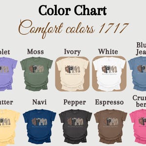 May include: A colour chart showing t-shirts in a range of colours: violet, moss, ivory, white, blue jean, butter, navy, pepper, espresso, and crunch berry. Each shirt has a graphic design and the text "Advanced Practice Registered Nurse".
