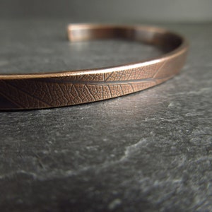close up view of leaf vein texture on bronze metal bangle