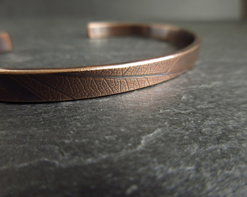 close up view of leaf vein texture on bronze metal bangle