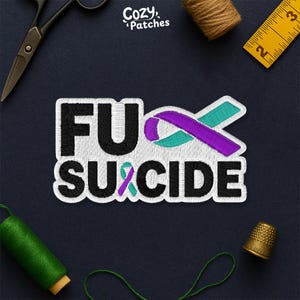 May include: Embroidered patch with the words "FU SUICIDE" in black, white, and purple. The patch includes a purple and teal ribbon design, and the brand name "Cozy Patches". The patch is surrounded by sewing tools.