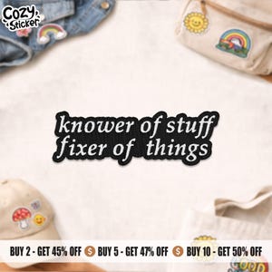 Peut inclure: Un écusson brodé noir avec le texte "knower of stuff fixer of things" en blanc. L'écusson est entouré d'autres écussons et accessoires, dont une veste en jean, un sac banane et une casquette de baseball.