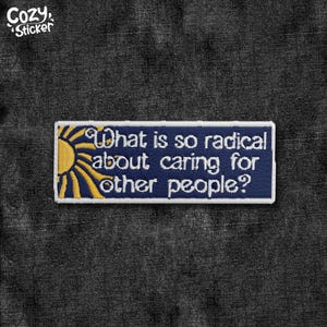 Peut inclure: Écusson brodé avec le texte "What is so radical about caring for other people ?" en blanc sur fond bleu marine. Le patch présente un motif de soleil jaune sur le côté gauche et une bordure blanche.