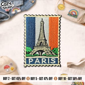 May include: Embroidered patch featuring the Eiffel Tower in Paris, France. The design is set against a vertical tricolor background of blue, white, and orange, resembling a postage stamp. The word "PARIS" is displayed at the bottom.