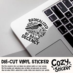 May include: A die-cut vinyl sticker with a black and white illustration of a bird perched on a flowering branch. The sticker reads "RADICALIZED BY BASIC DECENCY" in a stylized font. The sticker is on a white laptop.
