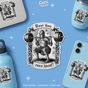 Peut inclure: Un autocollant avec une illustration en noir et blanc d'un chevalier soulevant une barre. Le texte "Dost thou even hoist?" est au-dessus et en dessous du chevalier. L'autocollant est affiché sur un ordinateur portable, un gobelet, un téléphone et une gourde.