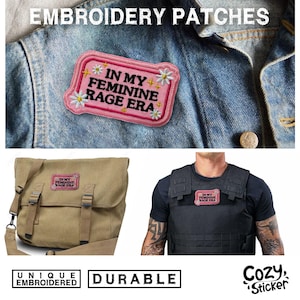 May include: Pink embroidered patch with the text "IN MY FEMININE RAGE ERA" and daisy accents. The patch is shown on a denim jacket, a canvas messenger bag, and a black vest. The image also includes the words "UNIQUE EMBROIDERED" and "DURABLE".
