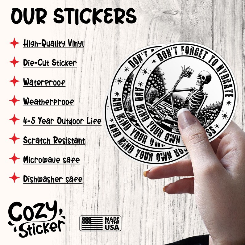 May include: A black and white sticker with a skeleton holding a glass of water and the text "Don't forget to hydrate and mind your own business". The sticker is on a wooden surface.
