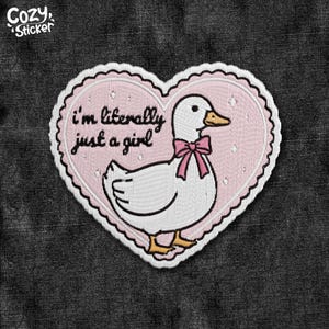 May include: Embroidered patch in the shape of a heart with a white duck wearing a pink bow. The patch has the text "I'm literally just a girl" in black script. The background is pink with white dots, and the border is white.