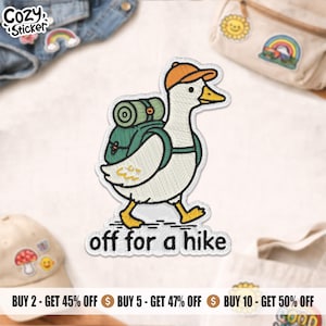 May include: Embroidered patch depicting a cartoon goose wearing an orange cap and a green backpack, walking. The text "off for a hike" is below the goose. The patch has a white border and is designed for clothing or accessories.