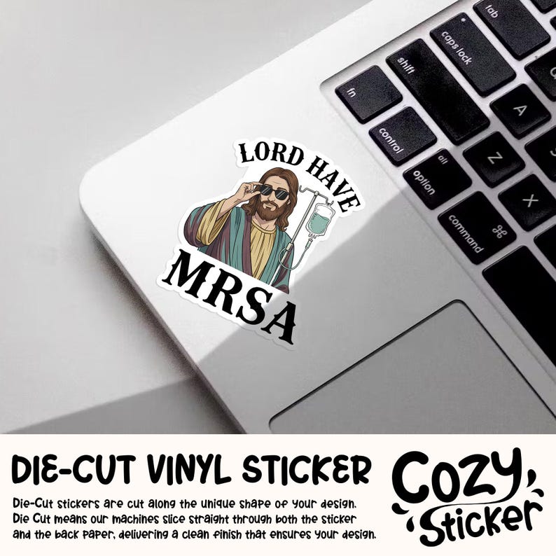 May include: A white die-cut vinyl sticker featuring an illustration of Jesus wearing sunglasses and an IV drip, with the words "LORD HAVE MRSA". The sticker is on a laptop.
