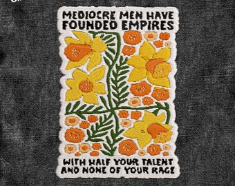 May include: Embroidered patch with the text "MEDIOCRE MEN HAVE FOUNDED EMPIRES" and "WITH HALF YOUR TALENT AND NONE OF YOUR RAGE". The patch features yellow and orange flowers with green leaves on a white background.