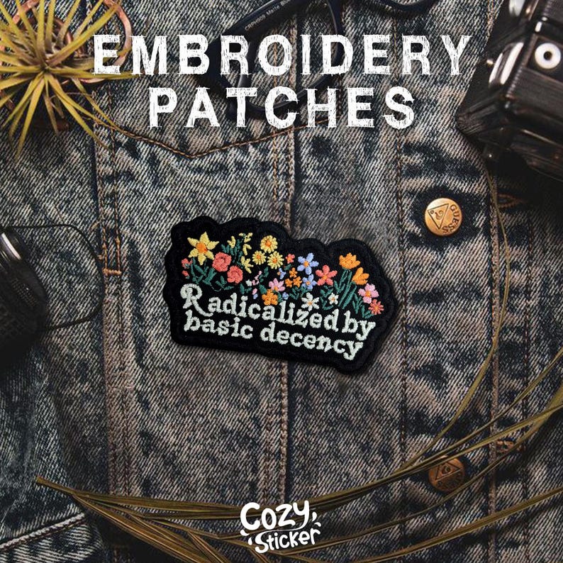 May include: Embroidered patch with floral design and the text "Radicalized by basic decency" on a denim jacket. The patch features colorful flowers in yellow, pink, and blue. The image also includes the text "Cozy Sticker".