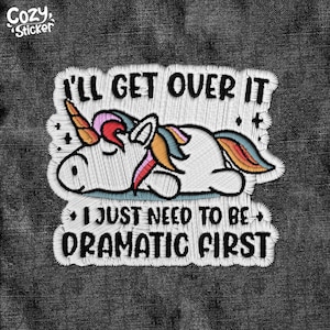 May include: Embroidered patch with a white unicorn lying down with a rainbow mane and tail. The text reads "I'll get over it, I just need to be dramatic first."