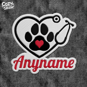 Peut inclure: Patch en forme de cœur blanc avec une empreinte de patte noire à l'intérieur, un cœur rouge au centre de l'empreinte de patte et un stéthoscope blanc enroulé autour du cœur. Le texte "Anyname" est brodé en rouge sur un fond blanc sous le cœur.