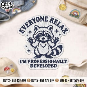 May include: A white embroidered patch featuring a dark blue raccoon with raised paws. The text reads EVERYONE RELAX at the top and I'M PROFESSIONALLY DEVELOPED at the bottom. The design includes small star accents on a white background.