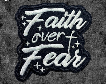 May include: Black and white embroidered patch with the text "Faith over Fear" in a stylized font. The patch has a distressed look and is surrounded by small white stars.