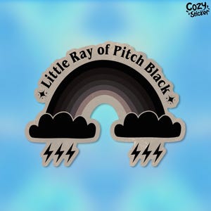 May include: A black and grey rainbow sticker with the text "Little Ray of Pitch Black" and lightning bolts.