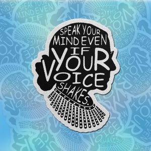 May include: A black and white patch in the shape of a silhouette with the text "SPEAK YOUR MIND EVEN IF YOUR VOICE SHAKES." The patch has a white border and a design resembling a collar.