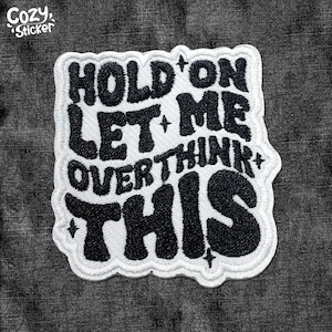 May include: White iron-on patch with black embroidered text that reads "Hold on let me overthink this".