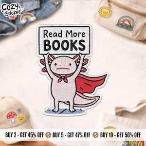 Peut inclure: Écusson brodé représentant un axolotl rose tenant une pancarte avec l'inscription "Read More BOOKS". L'axolotl porte une cape rouge et une écharpe rouge. L'écusson a une bordure blanche et est sur fond blanc.