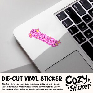 Puede incluir: Una pegatina de vinilo rosa troquelada sobre un port&aacute;til. La pegatina tiene el texto "Do You Guys Ever Think About Dying?" en una burbuja rosa con estrellas amarillas. El port&aacute;til es blanco con un teclado negro.