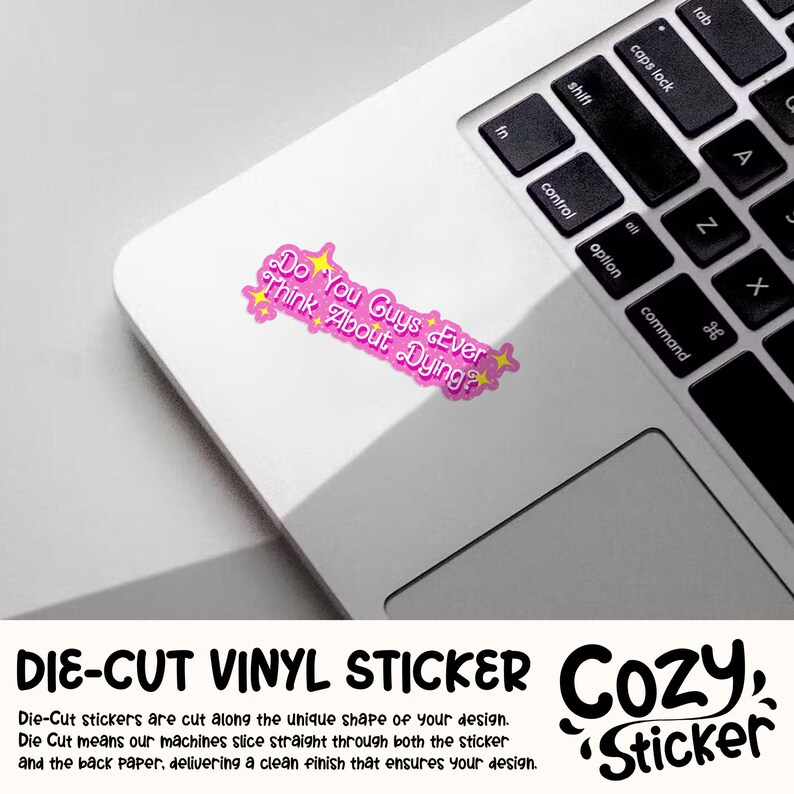 Puede incluir: Una pegatina de vinilo rosa troquelada sobre un port&aacute;til. La pegatina tiene el texto "Do You Guys Ever Think About Dying?" en una burbuja rosa con estrellas amarillas. El port&aacute;til es blanco con un teclado negro.