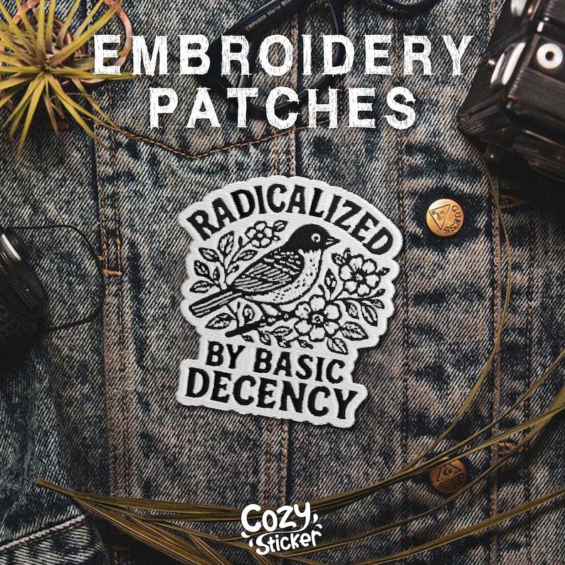 Puede incluir: Parche bordado con un dise&ntilde;o de p&aacute;jaro en blanco y negro, rodeado de flores y las palabras "RADICALIZED BY BASIC DECENCY". El parche est&aacute; sobre una chaqueta vaquera. Las palabras "EMBROIDERY PATCHES" est&aacute;n en la parte superior. El logotipo de Cozy Sticker est&aacute; en la parte inferior.
