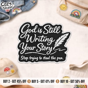 May include: Black embroidered patch with the text "God is Still Writing Your Story" and a feather illustration. The patch has a white border and the words "Stop trying to steal the pen."