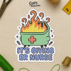 May include: Embroidered patch featuring a green dumpster with a red cross and flames, with the text "IT'S GIVING ER NURSE." The patch has a white border and is surrounded by sewing supplies.