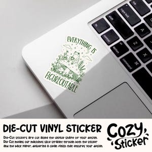May include: A die-cut vinyl sticker with a green illustration of a frog on a mushroom, with the text "EVERYTHING IS FIGUREOUTABLE". The sticker is on a white laptop. The sticker is from Cozy Sticker.