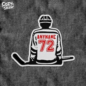 May include: Black and white silhouette of a hockey player wearing a red jersey with the number 72. The jersey has the text "ANYNAME" on it. The player is holding a hockey stick.