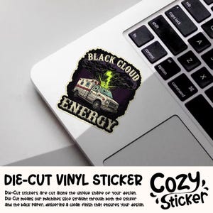 May include: A die-cut vinyl sticker featuring an ambulance with the words "BLACK CLOUD ENERGY". The ambulance is white with red accents, and a lightning bolt emanates from a dark cloud above it. The sticker is on a laptop.