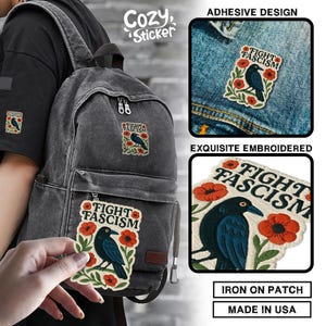 Puede incluir: Parche bordado con el texto "FIGHT FASCISM" y un p&aacute;jaro negro sobre una rama con flores rojas. El parche se muestra en una mochila y una chaqueta vaquera. El parche es para planchar y est&aacute; hecho en EE. UU.
