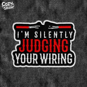 May include: Black and white embroidered patch with red text that reads "I'm silently judging your wiring".