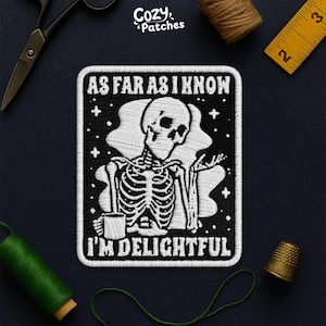 Peut inclure: Écusson brodé avec un fond noir et un motif de squelette blanc. Le texte "AS FAR AS I KNOW I'M DELIGHTFUL" est brodé au-dessus et en dessous du squelette. L'écusson est entouré de points blancs et de petites étoiles blanches.