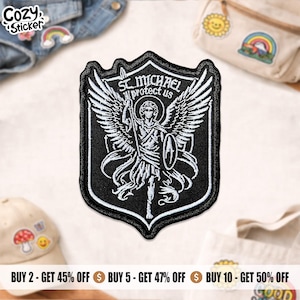 May include: Black and white embroidered patch featuring St. Michael, holding a spear and shield, with the text "ST MICHAEL protect us." The patch is shield-shaped with a black border. The patch is a Cozy Sticker product.