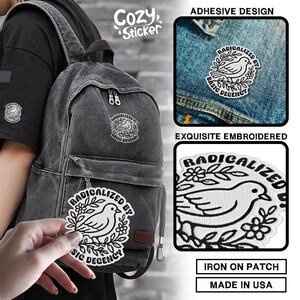May include: An embroidered patch featuring a dove and floral design, with the text "RADICALIZED BY BASIC DECENCY". The patch is shown on a denim jacket and a backpack. The image also shows the text "ADHESIVE DESIGN", "EXQUISITE EMBROIDERED", "IRON ON PATCH", and "MADE IN USA".