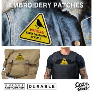 Pode incluir: Remendo triangular amarelo com uma silhueta de p&aacute;ssaro preto e o texto "WARNING! EASILY DISTRACTED BY BIRDS." O remendo &eacute; mostrado em uma jaqueta jeans, uma bolsa de lona e um colete preto. A imagem tamb&eacute;m inclui as palavras "UNIQUE EMBROIDERED" e "DURABLE."