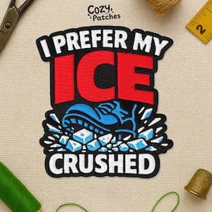 May include: Embroidered patch with the text "I PREFER MY ICE CRUSHED". The design features a blue shoe crushing ice cubes, with the word "ICE" in red. The patch is black with white and blue accents, perfect for clothing or accessories.