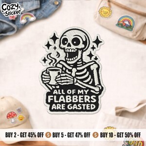 May include: Embroidered patch showing a black and white skeleton with a mug, and the text "ALL OF MY FLABBERS ARE GASTED." The patch has star accents and is designed to be sewn onto clothing or bags, offering a humorous touch.