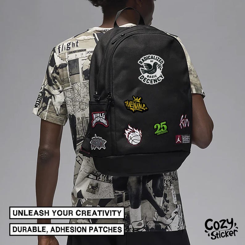 May include: Black backpack with multiple colorful patches. Patches include text and graphics such as a basketball, a bird, and the number 25. The backpack has a side pocket and a top handle. Text on the image reads: "UNLEASH YOUR CREATIVITY" and "DURABLE, ADHESION PATCHES."
